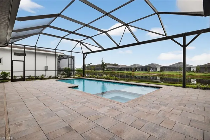 View of swimming pool with a lanai, a residential view, a sunroom, a pool with connected hot tub, and a patio