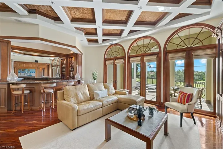 with beam ceiling, wood-type flooring, coffered ceiling, and french doors