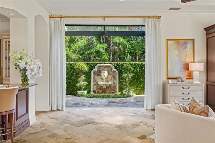 Doorway to outside featuring plenty of natural light, crown molding, and light tile patterned floors