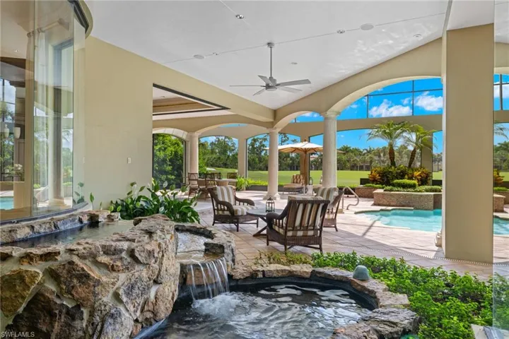 View of patio / terrace with pool water feature, a jacuzzi, and ceiling fan