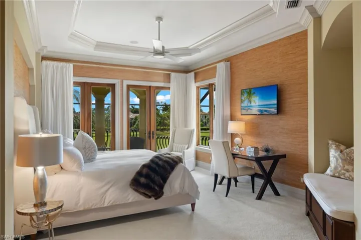 Bedroom with french doors, access to outside, ceiling fan, light carpet, and a raised ceiling