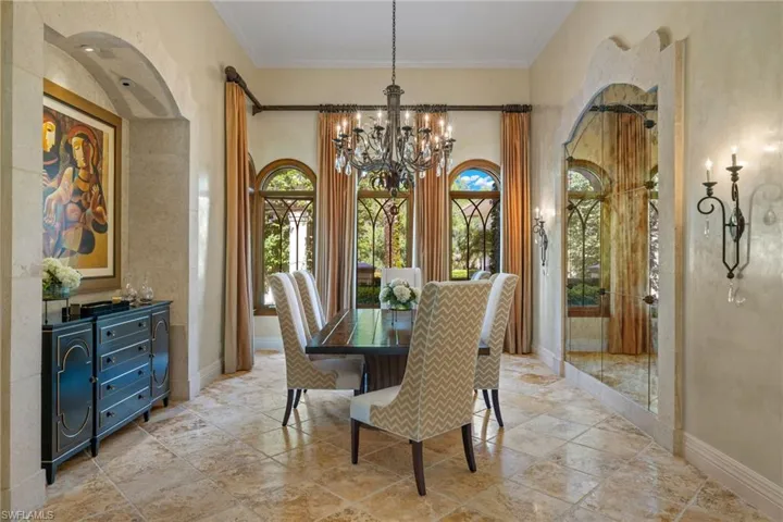 Tiled dining room with a notable chandelier and ornamental molding