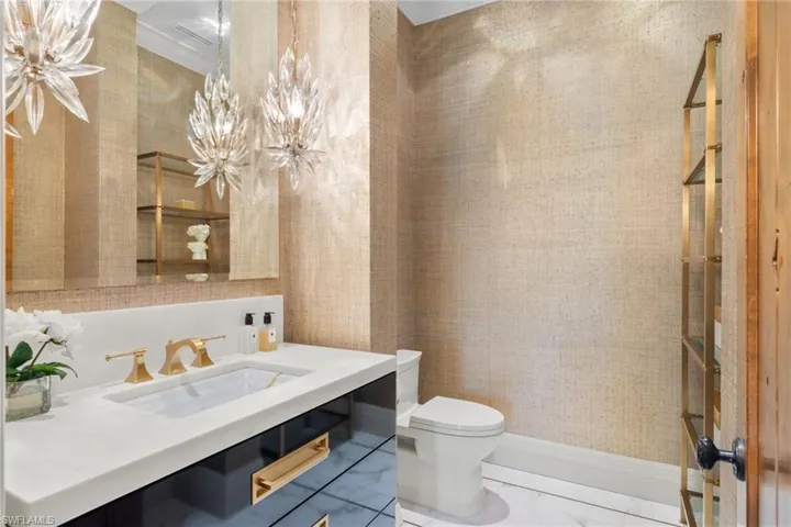 Bathroom featuring vanity, ornamental molding, tile patterned flooring, and toilet