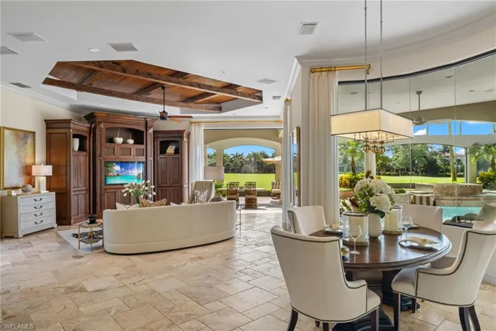 Dining area with a raised ceiling, wood ceiling, light tile patterned floors, and ceiling fan