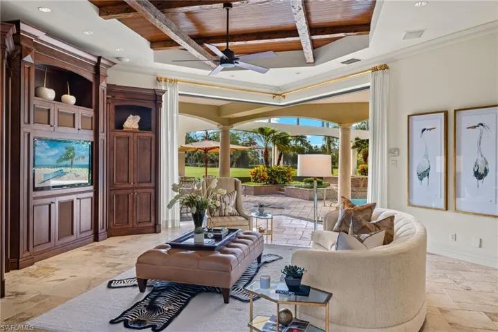 Tiled living room featuring beamed ceiling, coffered ceiling, wood ceiling, and ceiling fan