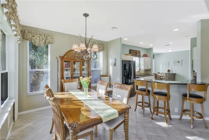 Dining area featuring plenty of natural light, light tile patterned floors, and a chandelier