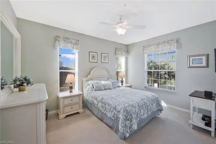 Bedroom featuring multiple windows, carpet flooring, and ceiling fan