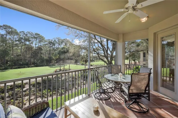Balcony with outdoor dining area, a ceiling fan, and golf course view