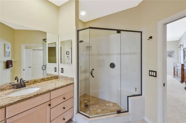 Full bathroom with vanity, a shower stall, and light colored carpet