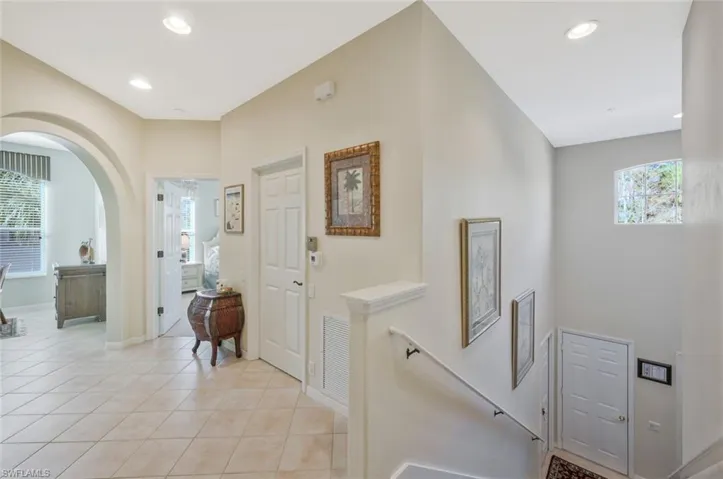 Foyer entrance featuring plenty of natural light, light tile patterned floors, arched walkways, and recessed lighting