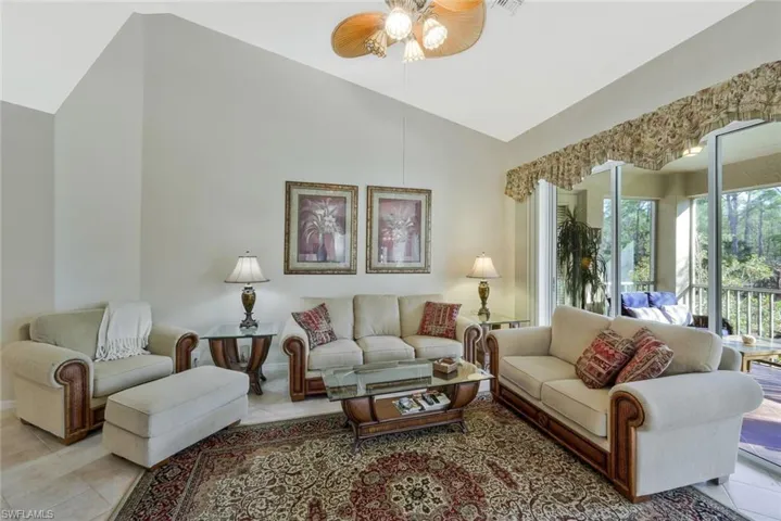 Tiled living area with lofted ceiling and a ceiling fan