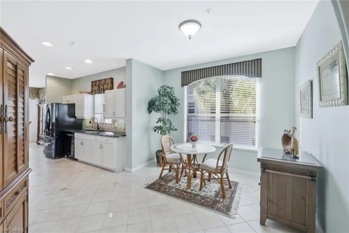 Dining area with light tile patterned floors and recessed lighting
