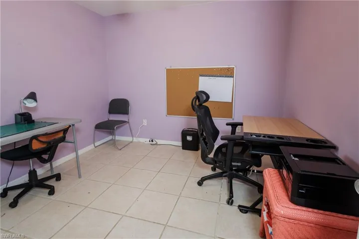 Office space featuring light tile patterned flooring and baseboards
