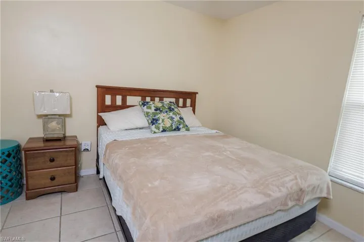 Tiled bedroom featuring baseboards