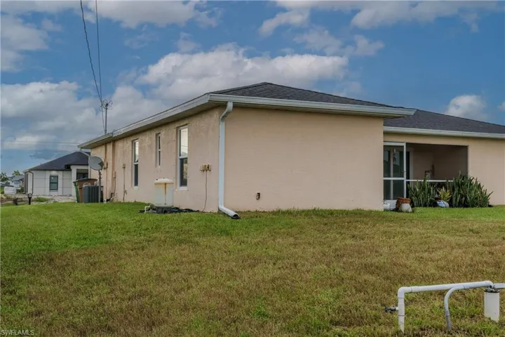 Back of property featuring stucco siding and a yard