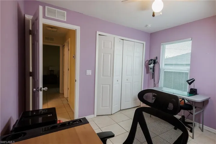 Office space featuring light tile patterned floors and a ceiling fan