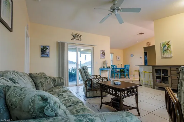 Living area featuring light tile patterned floors and a ceiling fan