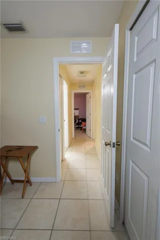 Hallway with light tile patterned flooring and an office area