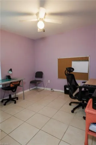 Office area with light tile patterned floors and a ceiling fan