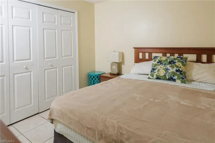 Bedroom featuring light tile patterned floors and a closet