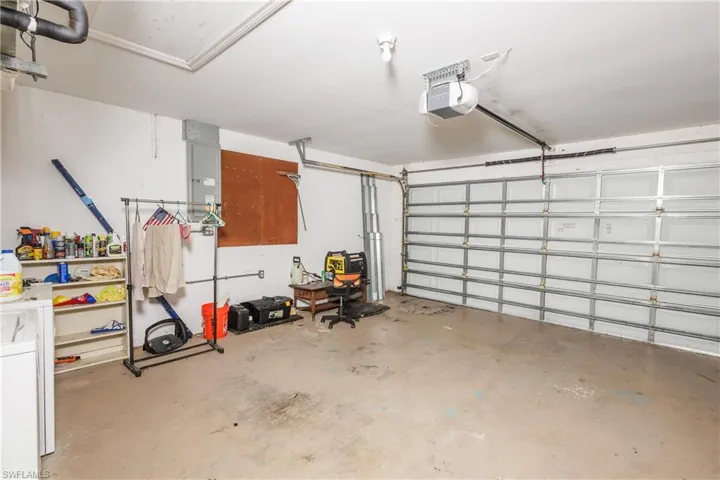 Garage featuring a garage door opener and electric panel