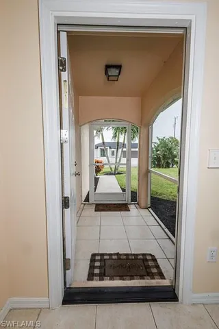 Doorway with light tile patterned flooring