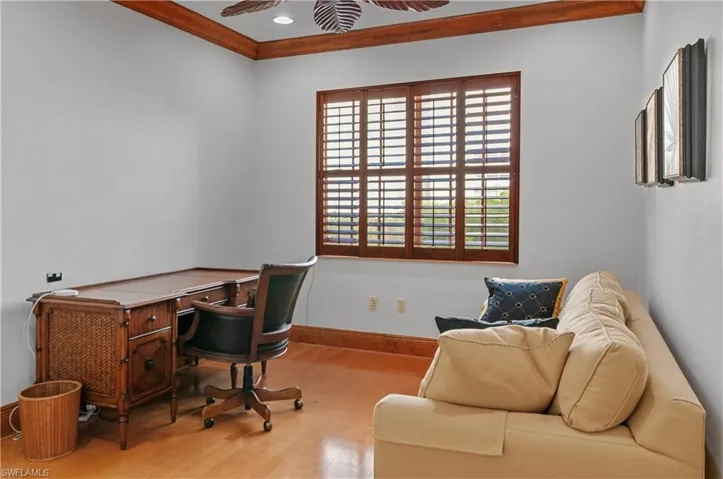 Home office featuring light hardwood / wood-style floors, ornamental molding, and ceiling fan