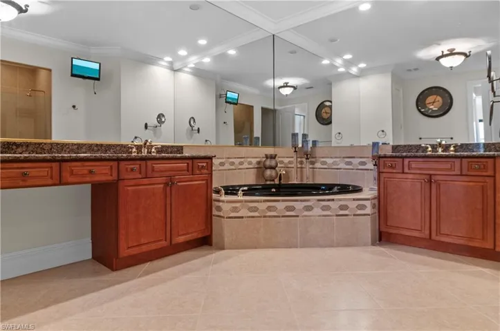 Bathroom with vanity, crown molding, and tile patterned floors