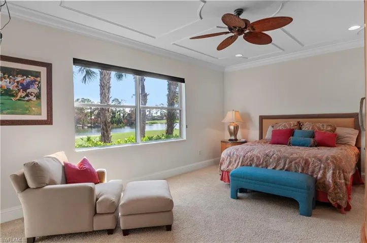 Bedroom with carpet flooring, crown molding, a water view, and ceiling fan