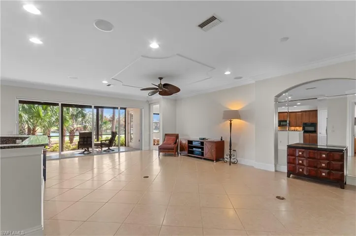 Tiled living room with crown molding and ceiling fan
