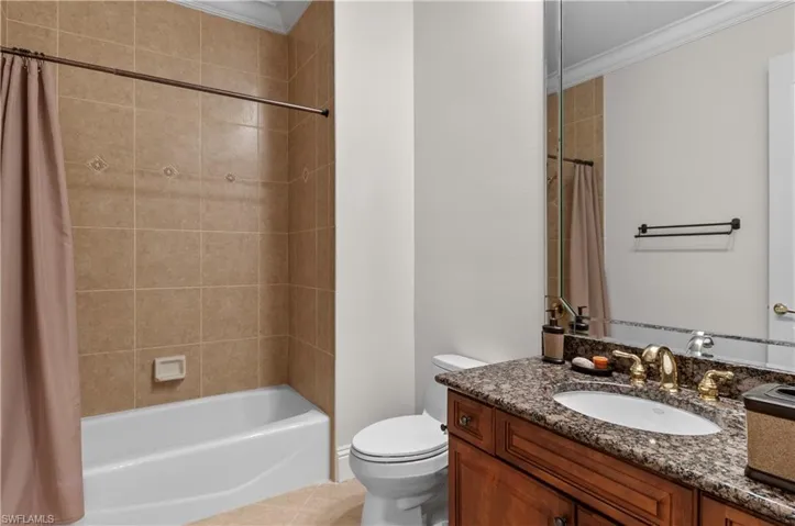 Full bathroom featuring vanity, toilet, ornamental molding, and shower / bath combo