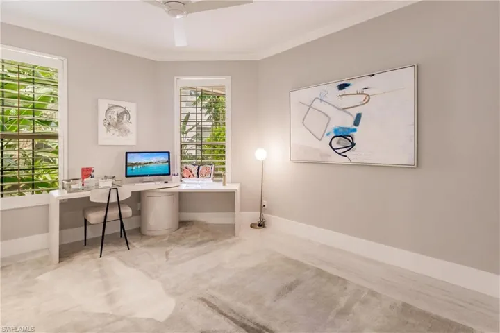 Carpeted home office featuring crown molding and ceiling fan