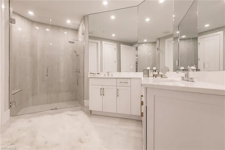 Bathroom featuring a shower with door and vanity