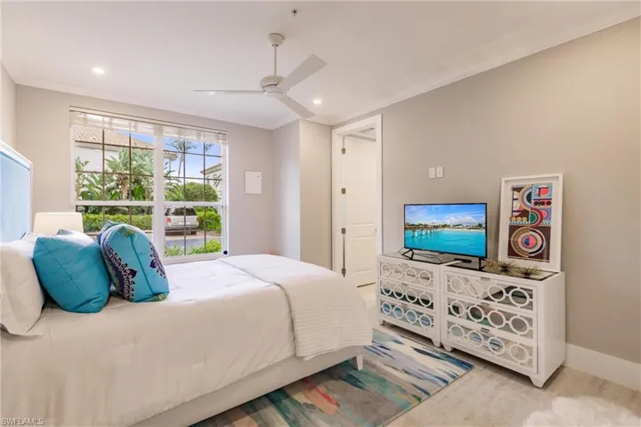 Bedroom featuring light colored carpet, ceiling fan, and ornamental molding
