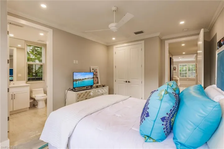 Bedroom with ceiling fan, ornamental molding, a closet, and ensuite bathroom
