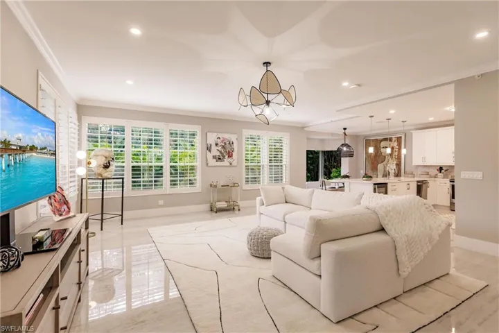 Living room featuring crown molding and plenty of natural light