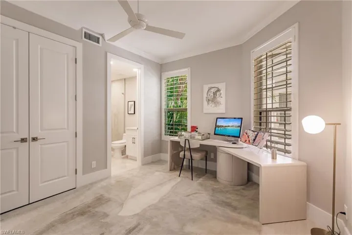 Office area with crown molding, ceiling fan, and light carpet