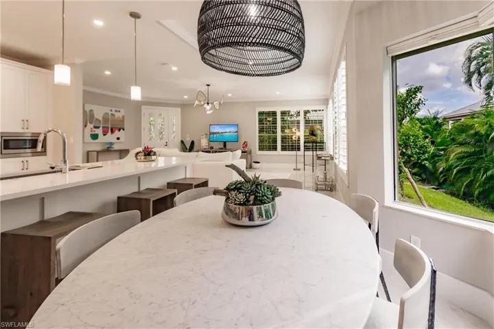 Dining space with ornamental molding, an inviting chandelier, and sink