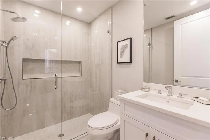 Bathroom featuring vanity, toilet, and walk in shower