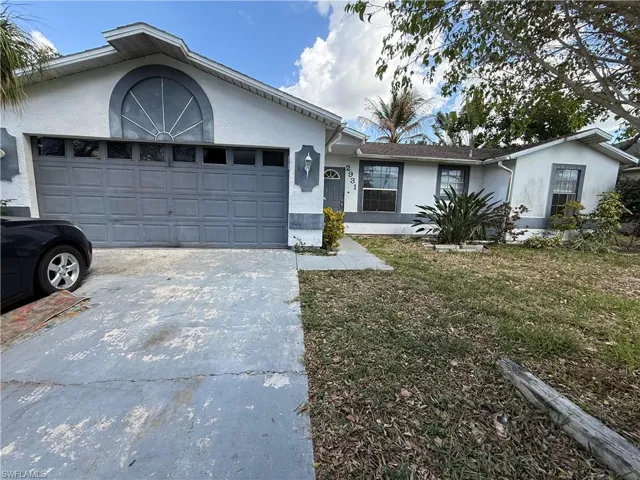 Ranch-style home featuring stucco siding, an attached garage, concrete driveway, and a front lawn