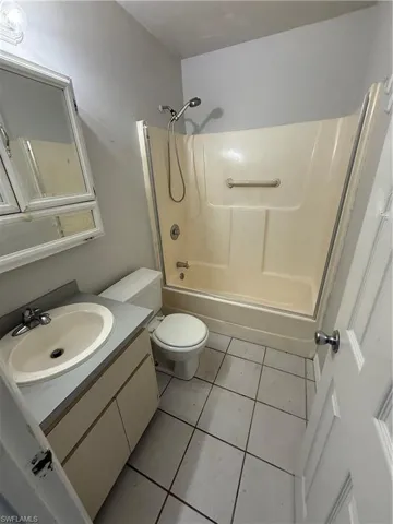 Full bath featuring vanity, shower / bath combination, and light tile patterned floors