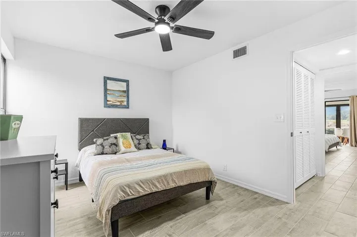 Bedroom featuring a ceiling fan, baseboards, visible vents, and light wood-style floors
