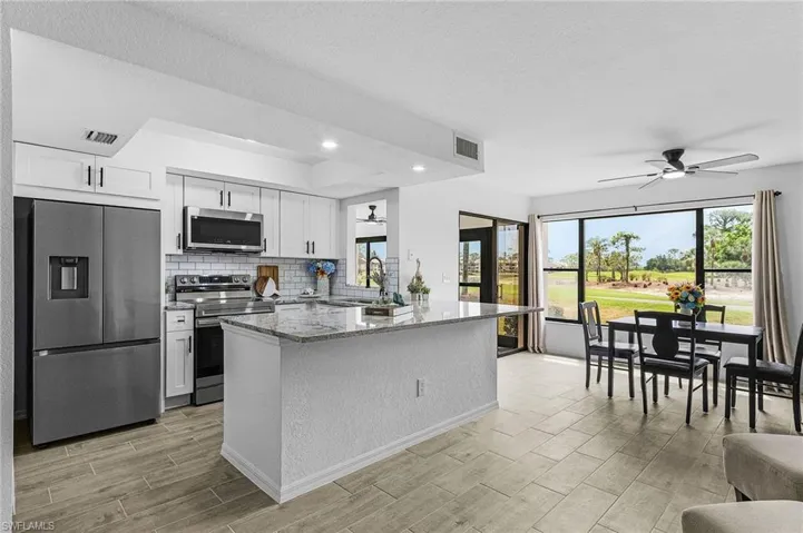 Kitchen featuring stainless steel appliances, ceiling fan, visible vents, and wood tiled floor