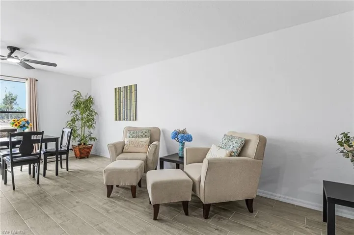 Sitting room with ceiling fan, baseboards, and wood tiled floor