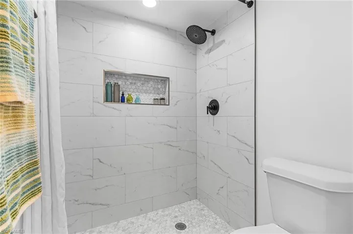 Bathroom featuring a stall shower and toilet