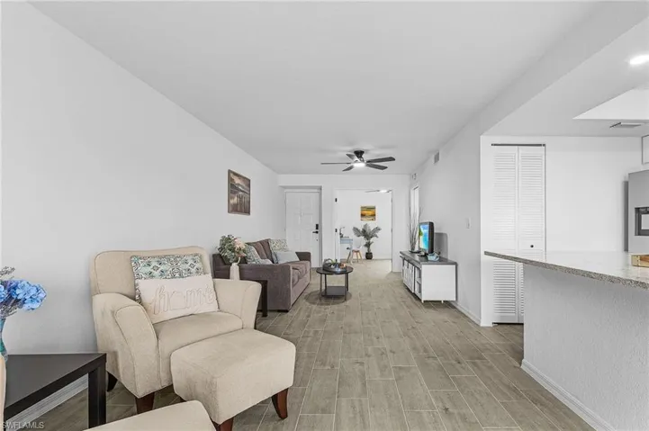 Living area featuring baseboards, ceiling fan, light wood-style flooring, and visible vents