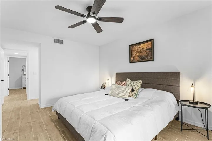 Bedroom featuring visible vents, wood tiled floor, baseboards, and a ceiling fan