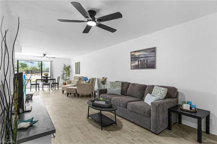 Living area with baseboards, a ceiling fan, and wood finish floors