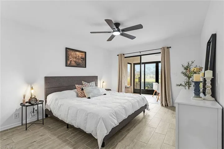 Bedroom featuring access to outside, wood finish floors, ceiling fan, and baseboards