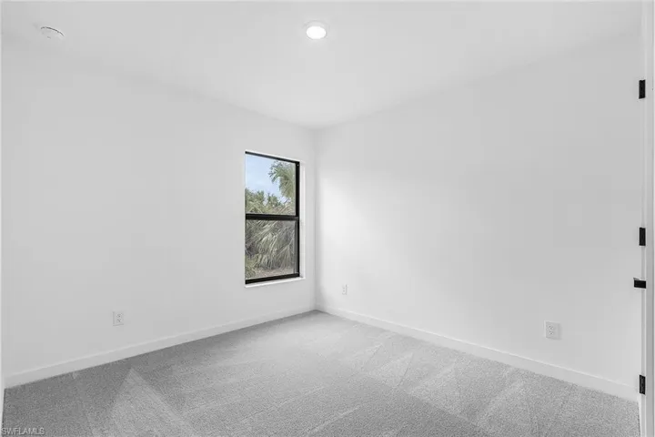 Carpeted spare room with baseboards